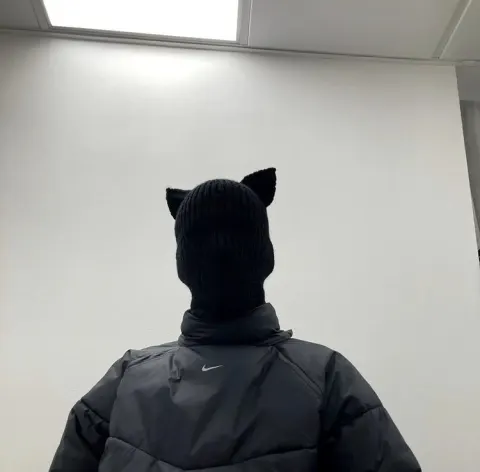 Pessoa com balaclava de orelha de gato