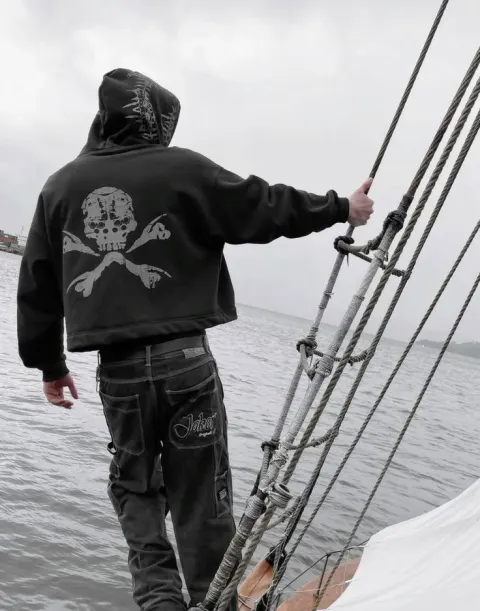 Jovem em barco com moletom de caveira