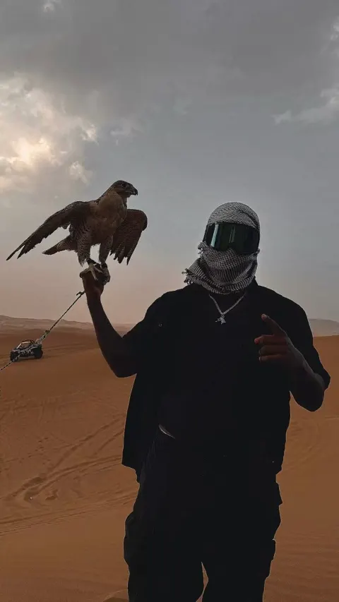 Homem com falcão no deserto