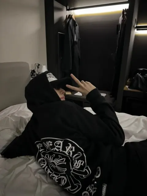 Jovem de moletom preto e boné