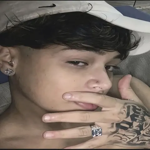 Jovem com boné e tatuagem na mão