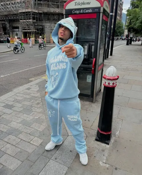 Jovem em conjunto de moletom azul na rua