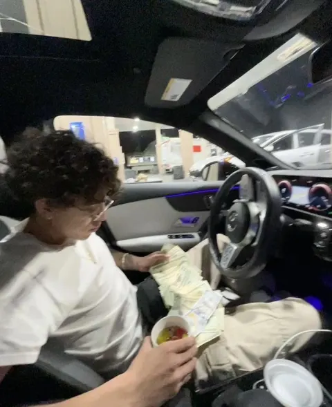 Jovem no carro com dinheiro
