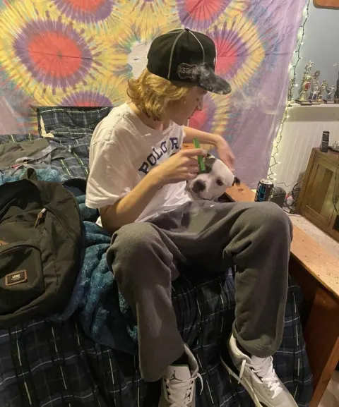 Jovem com cachorro em quarto