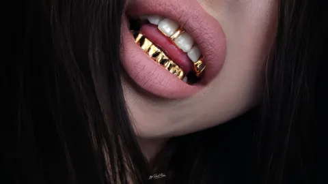 Close-up de lábios com grillz dourados