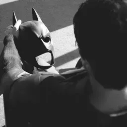 Batman segurando a máscara