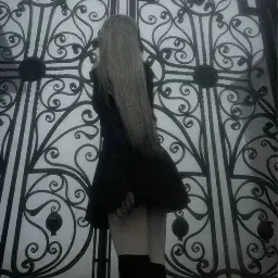 Garota de costas em portão de ferro