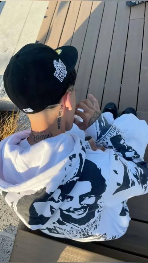 Jovem com boné e moletom estampado